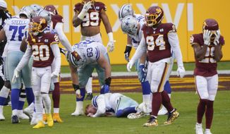 Players reacting to seeing Dallas Cowboys quarterback Andy Dalton (14) lying on the ground after getting hit by Washington Football Team inside linebacker Jon Bostic (53) in the second half of an NFL football game, Sunday, Oct. 25, 2020, in Landover, Md. (AP Photo/Susan Walsh)