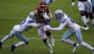 Dallas Cowboys safety Donovan Wilson (37) and cornerback Trevon Diggs (27) fail to stop Washington Football Team running back Antonio Gibson (24) from scoring a touchdown during the first half of an NFL football game, Sunday, Oct. 25, 2020, in Landover, Md. (AP Photo/Susan Walsh)