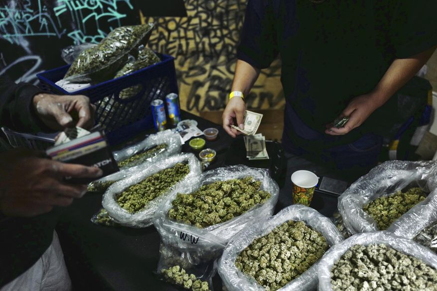 FILE - In this April 15, 2019, file photo, a vendor makes change for a marijuana customer at a cannabis marketplace in Los Angeles. Voters in four states could embrace broad legal marijuana sales on Election Day, setting the stage for a watershed year for the industry that could snowball into neighboring states as well as reshape policy on Capitol Hill. The Nov. 3, 2020, contests will take place in markedly different regions of the country, New Jersey, Arizona, South Dakota and Montana and approval of the proposals would highlight how public acceptance of cannabis is cutting across geography, demographics and the nation&#x27;s deep political divide. (AP Photo/Richard Vogel, File)
