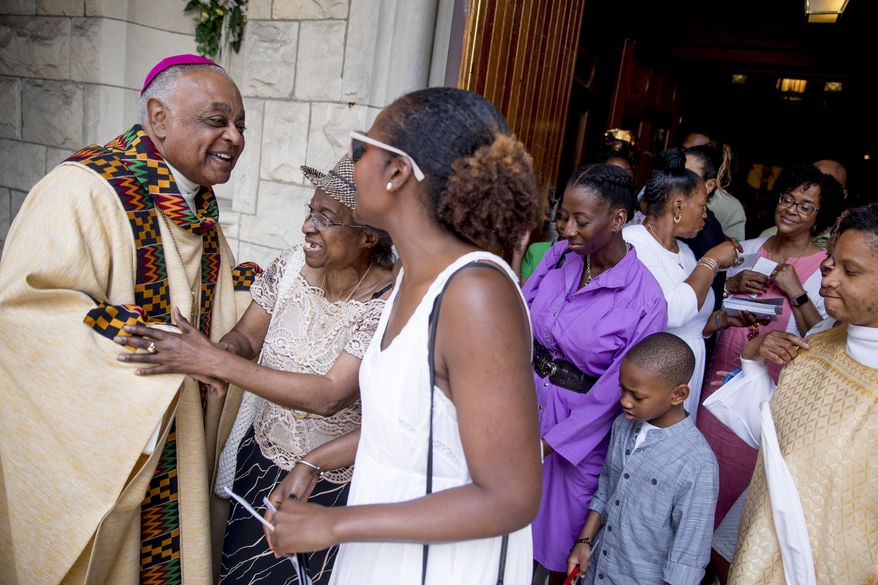 FILE - In this Sunday, June 2, 2019, file photo, Washington D.C. Archbishop Wilton Gregory, left, greets parishioners following Mass at St. Augustine Church in Washington. Pope Francis has named 13 new cardinals, including Washington D.C. Archbishop Wilton Gregory, who would become the first Black U.S. prelate to earn the coveted red cap. In a surprise announcement from his studio window to faithful standing below in St. Peter’s Square, Sunday, Oct. 25, 2020, Francis said the churchmen would be elevated to a cardinal’s rank in a ceremony on Nov. 28. (AP Photo/Andrew Harnik, File)