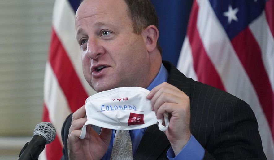 FILE - In this Tuesday, Oct. 20, 2020, file photo, Colorado Gov. Jared Polis holds up a face mask featuring the state&#x27;s new advertising campaign to encourage residents to protect against COVID-19 during a news conference about the steady increase in cases of the new coronavirus in the state in Denver. Colorado Gov. Polis is quarantining himself after learning that Aurora Mayor Mike Coffman tested positive for the coronavirus. Coffman&#x27;s diagnosis on Sunday, Oct. 25, 2020, came over a week after he and the governor appeared with other officials at a news conference. A Polis spokesperson said the governor would quarantine while waiting to hear from contact tracers. Coffman said he worked from home starting Thursday after not feeling well and his symptoms were gone by Saturday. He says he got a rapid test Sunday in hopes of being cleared to return to his office and schedule but will now quarantine at home. (AP Photo/David Zalubowski, File)