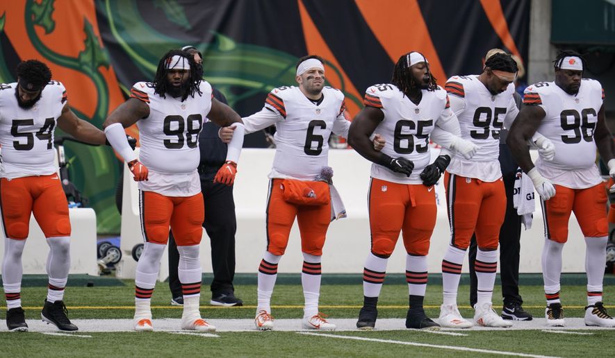 Cleveland Browns quarterback Baker Mayfield (6) locks arms with teammates during the national anthem before an NFL football game against the Cincinnati Bengals, Sunday, Oct. 25, 2020, in Cincinnati. (AP Photo/Michael Conroy)