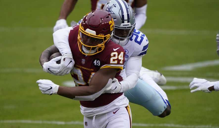 Washington Football Team running back Antonio Gibson (24) is tackled by Dallas Cowboys free safety Xavier Woods (25) in the first half of an NFL football game, Sunday, Oct. 25, 2020, in Landover, Md. (AP Photo/Susan Walsh)