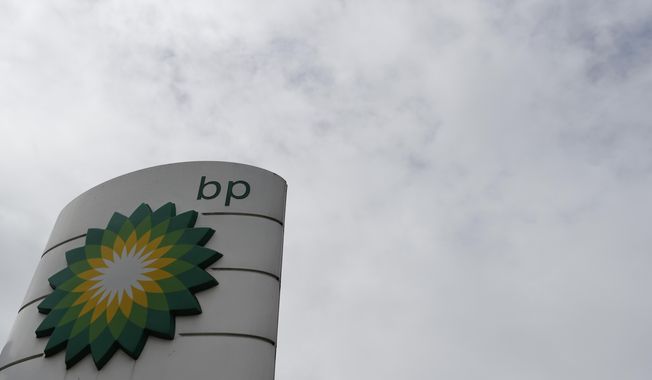 The logo of British Petroleum, BP, adorns a BP petrol station in west London, Tuesday, Aug. 4, 2020.  BP said Tuesday it plans to increase spending on low-carbon technology, including renewable energy projects, and says it plans to slash dividends as it reports a second-quarter operating loss and the global oil company prepares for declining sales of fossil fuels. (AP Photo/Alastair Grant)