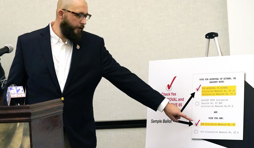 Jonathan C. Brown, 35, a Hattiesburg businessman and former U.S. Air Force staff sergeant, explains how to vote for Initiative 65, a strictly regulated medical marijuana program, that is on the general election ballot this November, during a Wednesday, Oct. 22, 2020 news conference in Jackson, Miss. (AP Photo/Rogelio V. Solis)