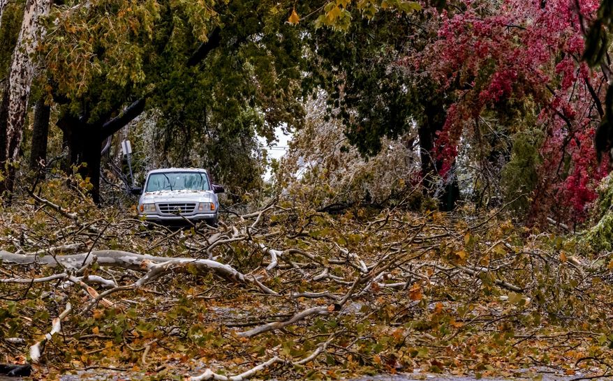 Broken tree limbs cover the road on NW 14th St. in Oklahoma City, Okla. on Tuesday, Oct. 27, 2020, after a winter blast covered the state with ice. (Chris Landsberger/The Oklahoman via AP)