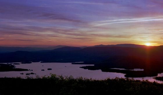FILE - In this May 19, 1998, file photo, the sun sets on Squam Lake, as seen from Red Hill in Moultonborough, N.H. New Hampshire filed a lawsuit Tuesday, Oct. 27, 2020, against the agrochemical giant Monsanto over what it says has been widespread PCB pollution in the state. The state said PCBs have fouled about numerous square miles of the Atlantic Ocean and 46 other water bodies including Squam Lake and stretches of the Souhegan River. (AP Photo/Jim Cole, File)