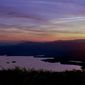 FILE - In this May 19, 1998, file photo, the sun sets on Squam Lake, as seen from Red Hill in Moultonborough, N.H. New Hampshire filed a lawsuit Tuesday, Oct. 27, 2020, against the agrochemical giant Monsanto over what it says has been widespread PCB pollution in the state. The state said PCBs have fouled about numerous square miles of the Atlantic Ocean and 46 other water bodies including Squam Lake and stretches of the Souhegan River. (AP Photo/Jim Cole, File)