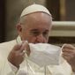 In this Tuesday, Oct. 20, 2020, file photo, Pope Francis puts on his face mask as he attends an inter-religious ceremony for peace in the Basilica of Santa Maria in Aracoeli, in Rome. (AP Photo/Gregorio Borgia, File)