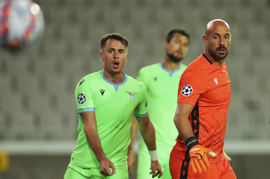 Lazio's goalkeeper Pepe Reina, right, and teammate Patric look at the ball during the Champions League Group F soccer match between Brugge and Lazio at the Jan Breydel stadium in Bruges, Belgium, Wednesday, Oct. 28, 2020. (AP Photo/ Olivier Matthys)