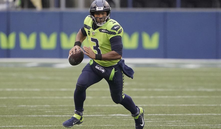 FILE - In this Oct. 11, 2020, file photo, Seattle Seahawks quarterback Russell Wilson looks for a receiver during the first half of the team&#x27;s NFL football game against the Minnesota Vikings in Seattle. Wilson and his Grammy-winning wife, pop singer Ciara, are putting their money and celebrity behind rebranding a charter school, which advocates hope will boost the troubled Washington state charter school sector that has suffered from enrollment problems after years of legal challenges. (AP Photo/Ted S. Warren, File)