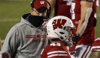 Wisconsin head coach Paul Chryst talks to players during the first half of an NCAA college football game against Illinois Friday, Oct. 23, 2020, in Madison, Wis. (AP Photo/Morry Gash)