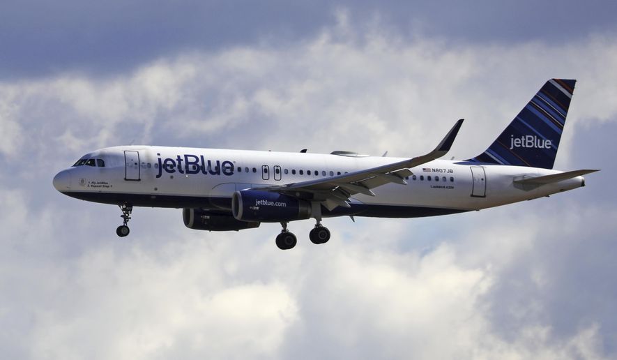 FILE - In this Oct. 18, 2019, file photo a JetBlue Airways flight flies in to Salt Lake City International Airport in Salt Lake City.   JetBlue says it plans to increase the number of seats it will fill on planes starting in December. That makes JetBlue the latest airline to retreat from blocking middle seats to give passengers more space because of the pandemic. (AP Photo/Rick Bowmer, File)