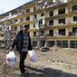 Vovik Zakharian, 72, walks past his apartment building damaged by shelling by Azerbaijan&#x27;s forces during a military conflict in Shushi, outside Stepanakert, the separatist region of Nagorno-Karabakh, Thursday, Oct. 29, 2020. Fighting over the separatist territory of Nagorno-Karabakh continued on Thursday, as the latest cease-fire agreement brokered by the U.S. failed to halt the flare-up of a decades-old conflict between Armenia and Azerbaijan. (AP Photo)