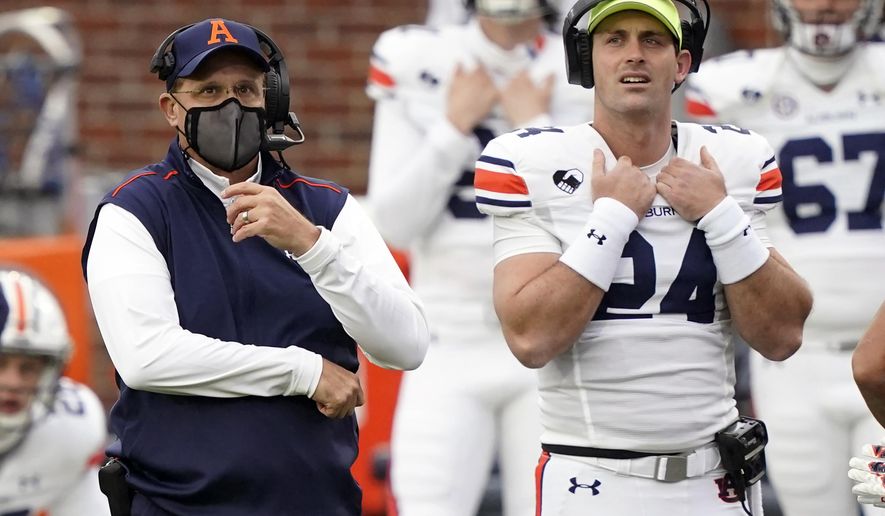 Auburn head coach Gus Malzahn, left, and Auburn quarterback Cord Sandberg (24) look at the scoreboard during the first half of an NCAA college football game against Mississippi in Oxford, Miss., Saturday Oct. 24, 2020. (AP Photo/Rogelio V. Solis)