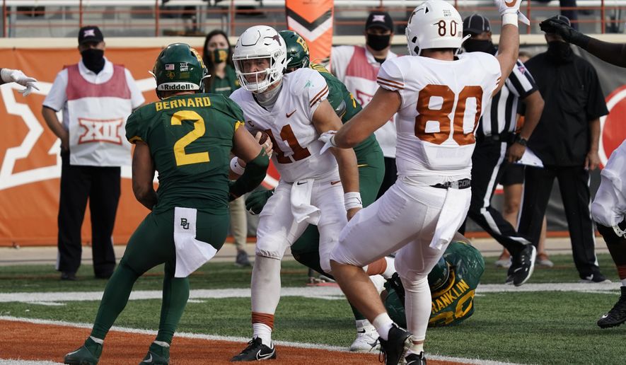 Texas' Sam Ehlinger (11) runs into the end zone for a touchdown against Baylor's Terrel Bernard (2) during the second half of an NCAA college football game in Austin, Texas, Saturday, Oct. 24, 2020. (AP Photo/Chuck Burton)