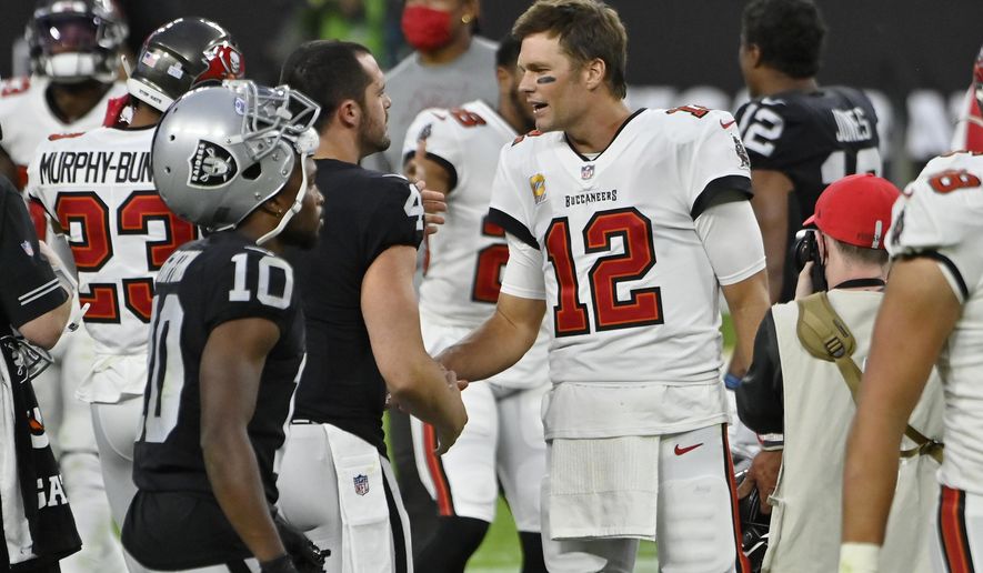 Tampa Bay Buccaneers quarterback Tom Brady (12) greets Las Vegas Raiders quarterback Derek Carr (4) after an NFL football game, Sunday, Oct. 25, 2020, in Las Vegas. (AP Photo/David Becker)