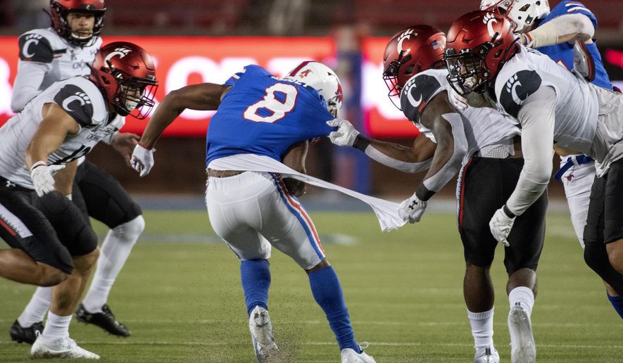 Cincinnati's Jaheim Thomas grabs the shirt of SMU kick returner Bryan Massey (8) on a kickoff return during the second half of an NCAA college football game Saturday, Oct. 24, 2020, in Dallas. Cincinnati won 42-13. (AP Photo/Jeffrey McWhorter)