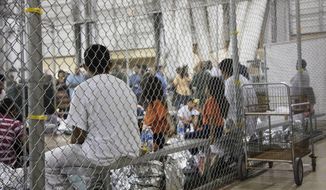 In this June 17, 2018, file photo provided by U.S. Customs and Border Protection, people who&#x27;ve been taken into custody related to cases of illegal entry into the United States, sit in one of the cages at a facility in McAllen, Texas. A federal judge on Thursday, Oct. 22, 2020, urged the Trump administration to do more to help court-appointed researchers find hundreds of parents who were separated from their children after they crossed the U.S.-Mexico border beginning in 2017. (U.S. Customs and Border Protection&#x27;s Rio Grande Valley Sector via AP, File)