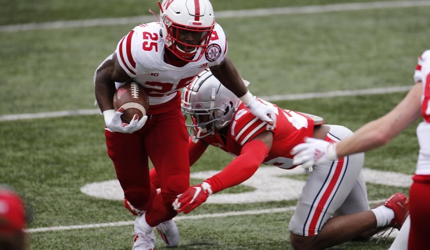 Nebraska running back Ronald Thompkins, left, runs past Ohio State defensive back Lloyd McFarquhar during the second half of an NCAA college football game Saturday, Oct. 24, 2020, in Columbus, Ohio. (AP Photo/Jay LaPrete)