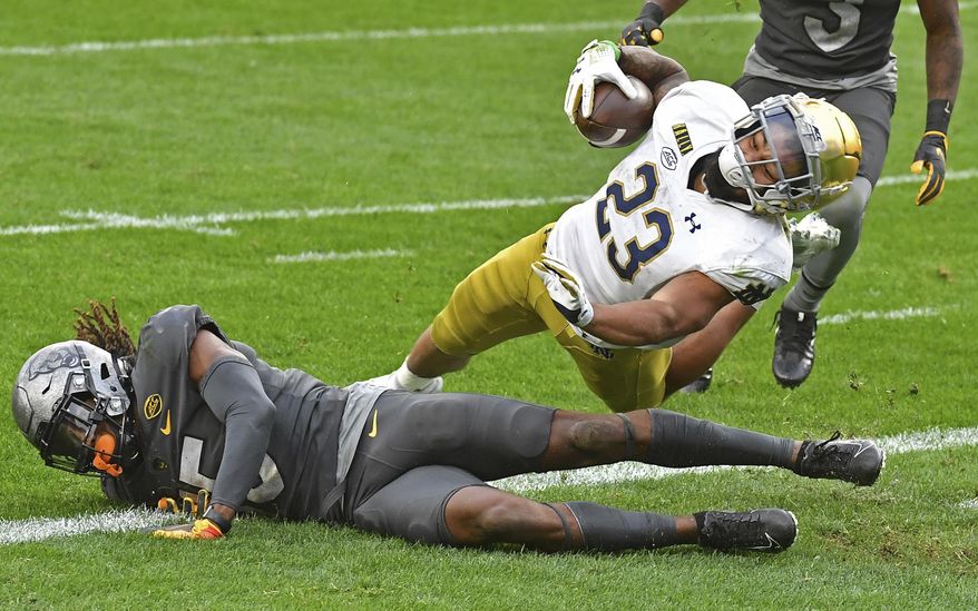 Notre Dame running back Kyren Williams dives into the end zone for a touchdown against Pitt defensive back Jason Pinnock in the second quarter of an NCAA college football game, Saturday, Oct. 24, 2020, in Pittsburgh. (Matt Freed/Pittsburgh Post-Gazette via AP)