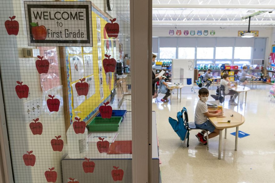First grade students sit at their desks set up for proper social distancing during the coronavirus outbreak at the Osborn School, Tuesday, Oct. 6, 2020, in Rye, N.Y. (AP Photo/Mary Altaffer)