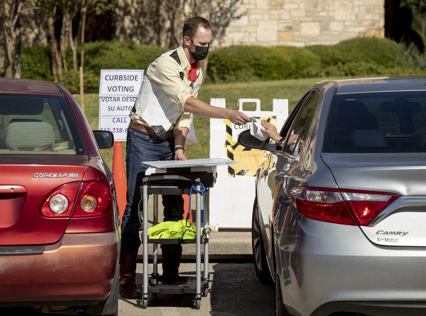 Election deputy John Hubbard sets up for a woman to vote curbside at Austin Oaks Church in Austin, Texas, on the last day of early voting on Friday Oct. 30, 2020. (Jay Janner/Austin American-Statesman via AP)