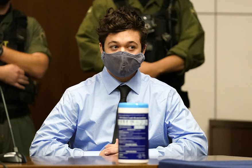 Kyle Rittenhouse looks at as he listens to defense attorney John Pierce during an extradition hearing in Lake County court Friday, Oct. 30, 2020, in Waukegan, Ill. Rittenhouse is accused of killing two protesters days after Jacob Blake was shot by police in Kenosha, Wis. (AP Photo/Nam Y. Huh, Pool)