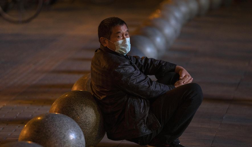 A man wearing a mask rests near barriers outside a shopping mall in Beijing on Friday, Oct. 30, 2020. China has managed to stem the spread of the coronavirus within the country even as the pandemic continues to surge globally. (AP Photo/Ng Han Guan)