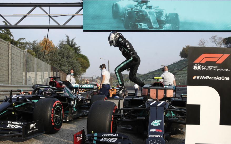 Mercedes driver Valtteri Bottas of Finland jumps out of his car after clocking the fastes time during qualification ahead of Sunday's Emilia Romagna Formula One Grand Prix, at the Enzo and Dino Ferrari racetrack, in Imola, Italy, Saturday, Oct. 31, 2020. (AP Photo/Luca Bruno, Pool)