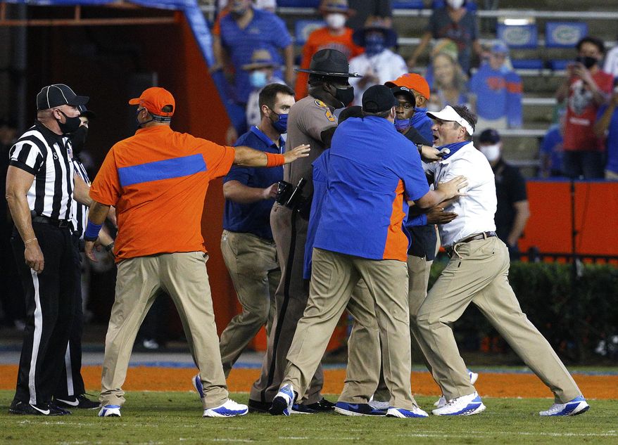 Florida coach Dan Mullen, right, is held back by coaches and law enforcement after a fight broke out at the end of the first half of the team&#39;s NCAA college football game against Missouri in Gainesville, Fla., Saturday, Oct. 31, 2020. (Brad McClenny/The Gainesville Sun via AP) **FILE**