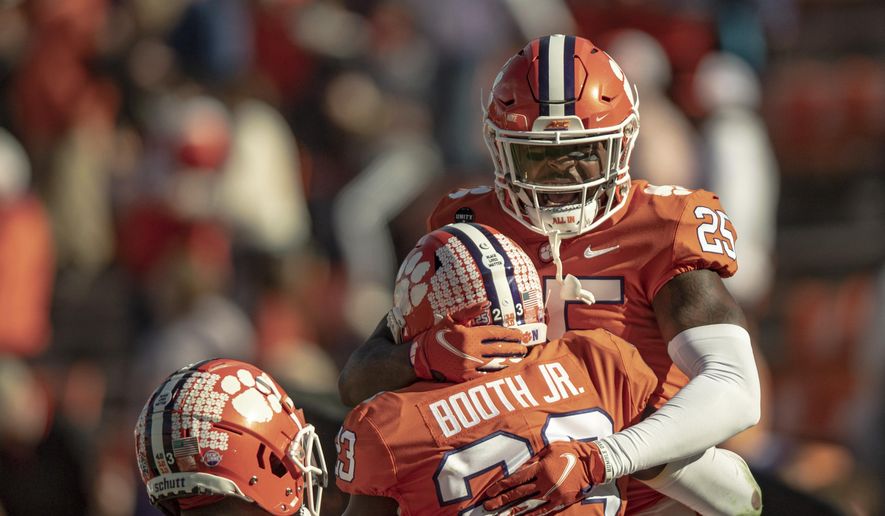 Clemson safety Jalyn Phillips (25) celebrates a defensive stop with cornerback Andrew Booth Jr. (23) during the second half of an NCAA college football game Saturday, Oct. 31, 2020, in Clemson, S.C. (Josh Morgan/Pool Photo via AP) **FILE**