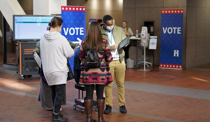Voters line up to vote at the Hennepin County Government Center, Tuesday, Oct. 27, 2020, in Minneapolis as early voting began for county residents. (AP Photo/Jim Mone)