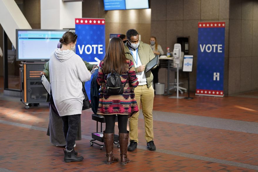 Voters line up to vote at the Hennepin County Government Center, Tuesday, Oct. 27, 2020, in Minneapolis as early voting began for county residents. (AP Photo/Jim Mone)