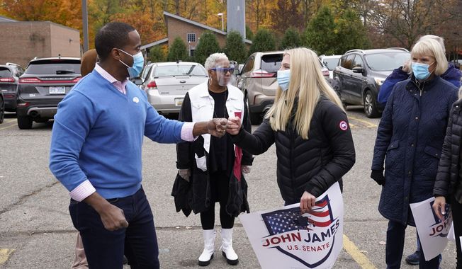 Republican U.S. Senate candidate John James, left, greets supporters in Farmington Hills, Mich., Monday, Oct. 26, 2020. (AP Photo/Paul Sancya) ** FILE **