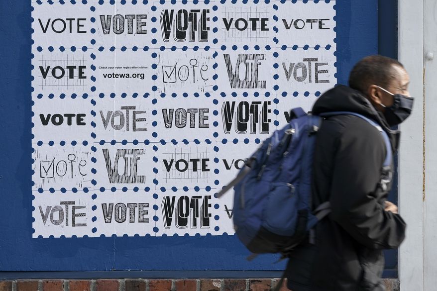 A pedestrian passes by a mural encouraging people to in Washington state to vote, Tuesday, Oct. 13, 2020, in downtown Seattle. A record number of voters in Washington have already returned their ballots as of Friday, Oct. 30, 2020, and other voters have until 8 p.m. Tuesday, Nov. 3, 2020 to drop off or mail their ballots or vote in person. (AP Photo/Ted S. Warren)