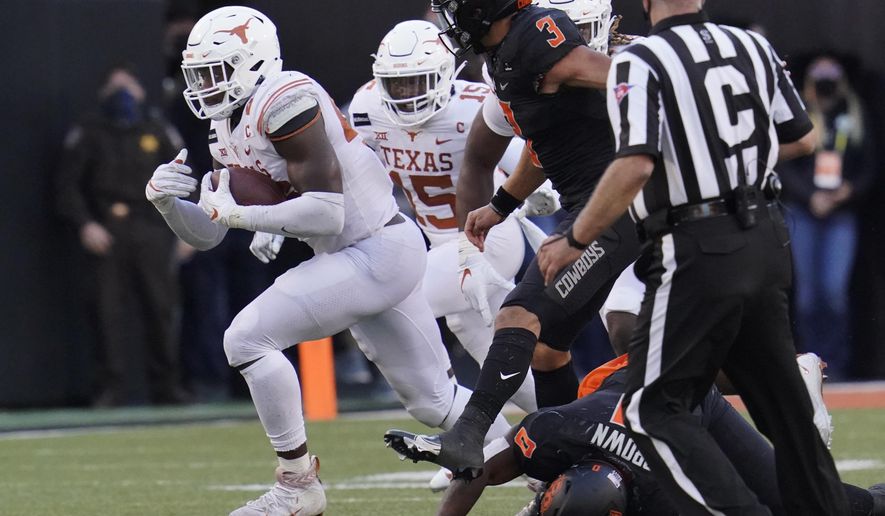 Texas's Joseph Ossai, left, carries a the ball after recovering an Oklahoma State fumble in the second half of an NCAA college football game in Stillwater, Okla., Saturday, Oct. 31, 2020. (AP Photo/Sue Ogrocki)