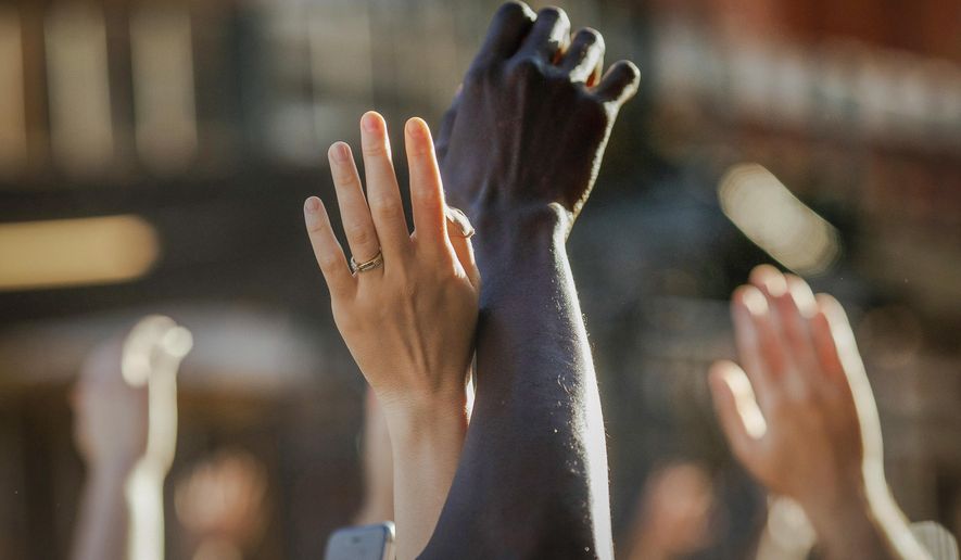 FILE - This photo from Sunday May 31, 2020, shows demonstrators raising their hands during a rally in Brooklyn, N.Y., for George Floyd, a black man who died in Minneapolis after being restrained by police officers. The chaos unleashed in 2020, amid the coronavirus pandemic, has created space for different voices to speak, for different conversations to be had and for different questions to be asked. (AP Photo/Kevin Hagen, File)