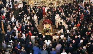 Believers pray by the coffin of Bishop Amfilohije, the head of the Serbian Orthodox Church in Montenegro, in Podgorica, Montenegro, Saturday, Oct. 31, 2020. The church said the 82-year-old died Friday from pneumonia caused by COVID-19. Amfilohije, known for his staunch anti-Western and pro-Russian political views, played a key role in leading the anti-government protests and putting together an opposition coalition that is currently trying to form the country&#39;s new government. (AP Photo/Risto Bozovic)