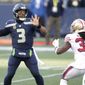 Seattle Seahawks quarterback Russell Wilson (3) makes a touchdown pass to wide receiver DK Metcalf (not shown) as San Francisco 49ers safety Marcell Harris, right, pressures during the first half of an NFL football game, Sunday, Nov. 1, 2020, in Seattle. (AP Photo/Scott Eklund)
