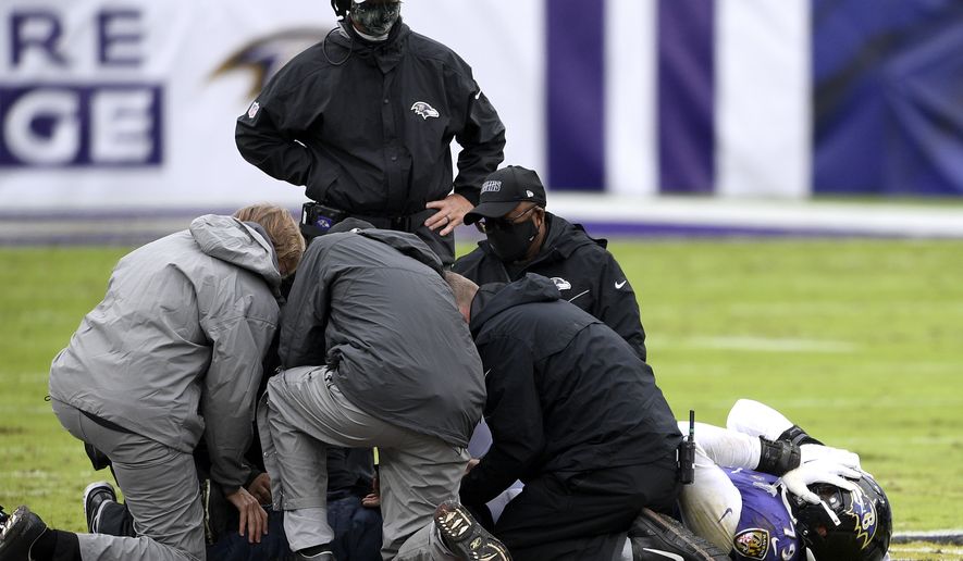 Trainers tend to Baltimore Ravens offensive tackle Ronnie Stanley, right, during the first half of an NFL football game against the Pittsburgh Steelers, Sunday, Nov. 1, 2020, in Baltimore. (AP Photo/Nick Wass)