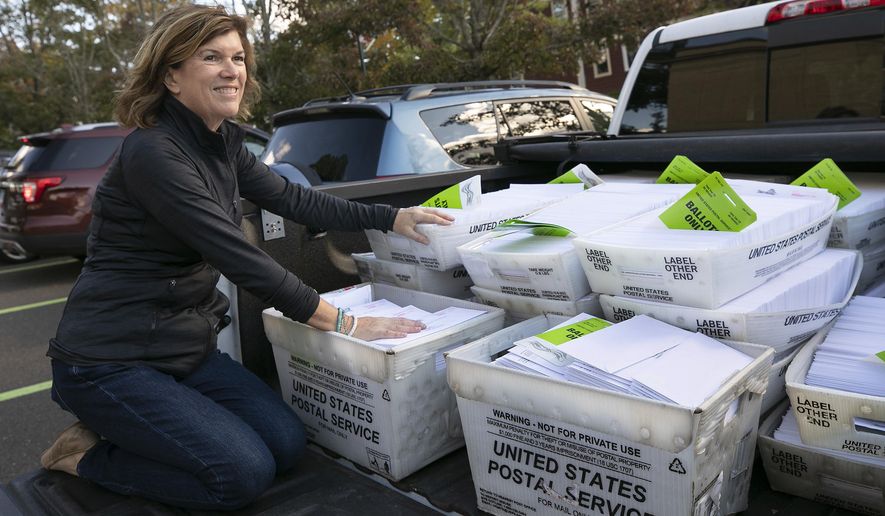 FILE - In this Friday, Oct. 2, 2020, file photo, Town Clerk Barbara Thompson gets ready to bring nearly 7,000 absentee ballots to the post office from Wallingford Town Hall, in Wallingford, Conn. While town clerks across Connecticut have so far received roughly 450,000 more absentee ballots than they did in the 2016 presidential election, hundreds of thousands of residents are still expected to go to the polls on Tuesday, Nov. 3, despite the pandemic. (Dave Zajac/Record-Journal via AP, File)
