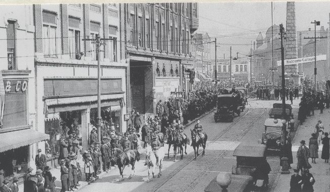 A downtown parade, honoring Col. Frederick W. Galbraith, Jr., National Commander of the American Legion, moves West on Patton Avenue in Asheville, N.C. in 1920. James Patton, who served on the city’s governing body in the 19th century, was a documented slave owner, holding up to 35 people at one time in bondage, according to historical records. That makes Patton Avenue, Asheville’s main east-west artery, an easy candidate for a city effort to rename roadways bearing slave owner monikers. (The Asheville Citizen-Times via AP)