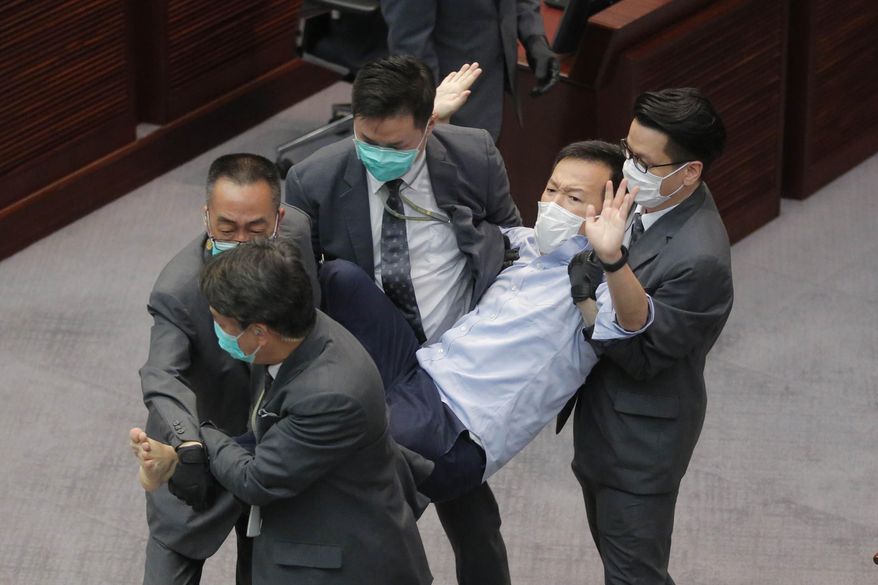 FILE - In this May 8, 2020, file photo, pan-democratic legislator Ray Chan is taken away by security guards during a Legislative Council's House Committee meeting in Hong Kong. Hong Kong police arrested seven people, including Chan, on Sunday, Nov. 1, 2020 over scuffles that broke out in the city’s legislature during a faceoff between pro-democracy and pro-Beijing lawmakers. (AP Photo/Kin Cheung)