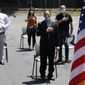 In this June 4, 2020, file photo, new citizens, socially distanced, recite the pledge of allegiance outside the U.S. Citizenship and Immigration Services building in Lawrence, Mass.  (AP Photo/Elise Amendola, File) **FILE**