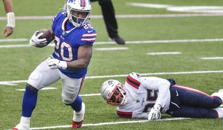 Buffalo Bills&#39; Zack Moss (20) rushes past New England Patriots&#39; Terrence Brooks (25) during the first half of an NFL football game Sunday, Nov. 1, 2020, in Orchard Park, N.Y. (AP Photo/Adrian Kraus)
