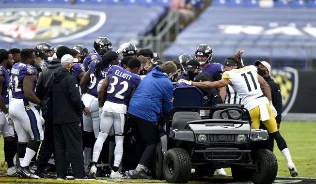 Pittsburgh Steelers wide receiver Chase Claypool (11) approaches a cart as Baltimore Ravens players surround offensive tackle Ronnie Stanley after he suffered an injury during the first half of an NFL football game, Sunday, Nov. 1, 2020, in Baltimore. (AP Photo/Gail Burton)