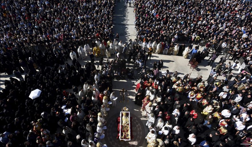 Thousands gathered by an open casket with Bishop Amfilohije&#x27;s body during the liturgy and and funeral outside the main temple in the capital Podgorica, Montenegro, Sunday, Nov. 1, 2020. Bishop Amfilohije died on Friday after contracting the coronavirus weeks ago. A mass funeral on Sunday was held for the popular head of the Serbian Orthodox Church in Montenegro in violation of restrictions that are in place against the new coronavirus. (AP Photo/Risto Bozovic)