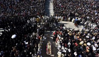 Thousands gathered by an open casket with Bishop Amfilohije&#39;s body during the liturgy and and funeral outside the main temple in the capital Podgorica, Montenegro, Sunday, Nov. 1, 2020. Bishop Amfilohije died on Friday after contracting the coronavirus weeks ago. A mass funeral on Sunday was held for the popular head of the Serbian Orthodox Church in Montenegro in violation of restrictions that are in place against the new coronavirus. (AP Photo/Risto Bozovic)