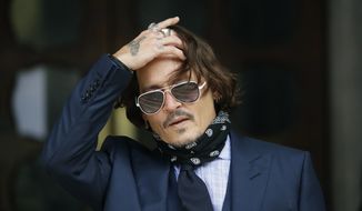 In this Tuesday, July 14, 2020, file photo, American actor Johnny Depp gestures to the media as he arrives at the High Court in London. The UK High Court has ruled against Johnny Depp in his libel suit against the owner of the Sun newspaper over a wife-beating allegation, it was reported on Monday, Nov. 2, 2020. (AP Photo/Matt Dunham, file)